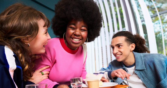 3 jeunes s'amusant ensemble autour d'un goûter