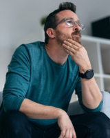 Un homme réfléchit en se tenant le visage 