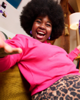 Jeune fille souriante assise dans un canapé 