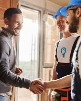 Un couple souriant discutent avec des travailleurs de chantier