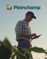 Agriculteur sur son téléphone au milieu d'un champs avec le logo Pleinchamp