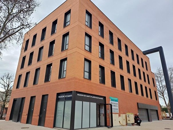 Façade moderne du bâtiment de la Maison de Santé de la Reynerie, un immeuble en briques avec de grandes fenêtres situé au 18 rue de Kiev à Toulouse