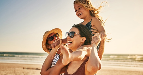 Un homme, une femme et une petite fille, heureux à la plage