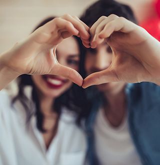 Homme et femme faisant un cœur avec leurs mains