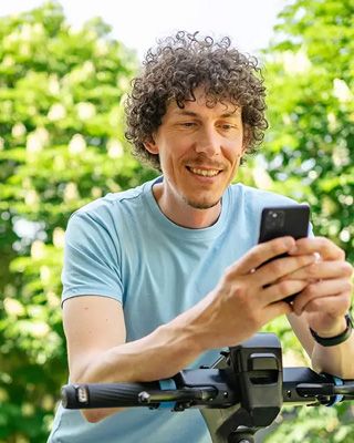 Homme souriant qui souscrit un livret d’épargne sur son téléphone mobile