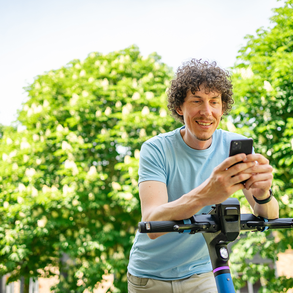 Homme souriant qui souscrit un livret d’épargne sur son téléphone mobile