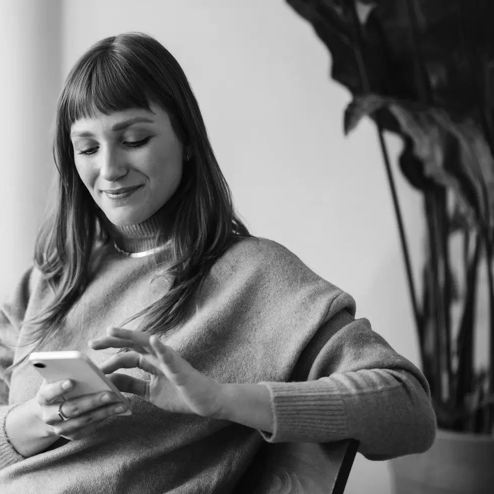 Jeune femme qui passe un ordre de bourse sur son smarpthone 