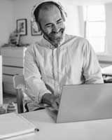 Homme qui regarde en souriant son ordinateur