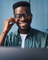 Homme qui regarde en souriant son ordinateur 
