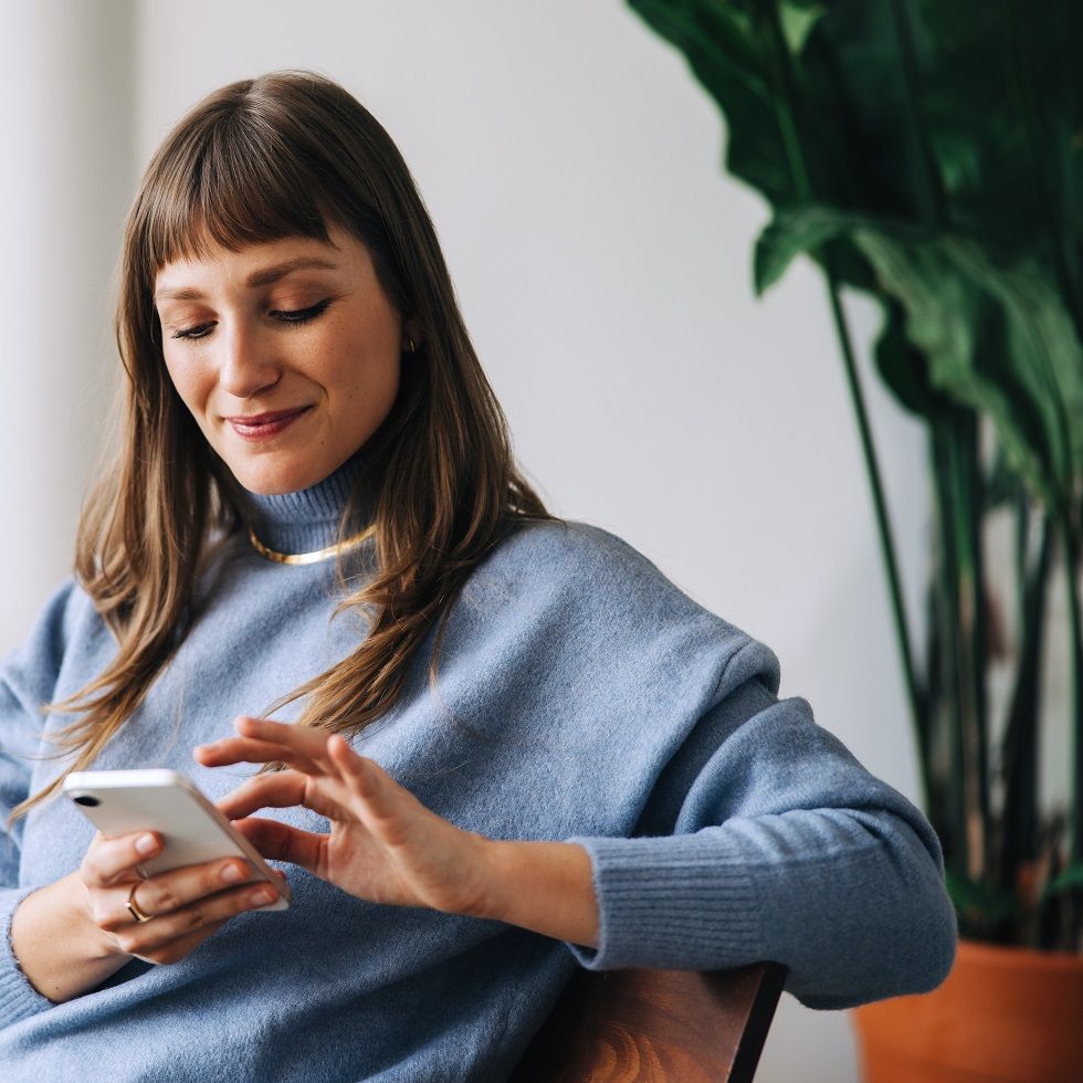 Jeune femme qui passe un ordre de bourse sur son smarpthone